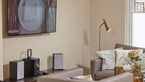 Un soggiorno moderno con un divano, un tavolino, una lampada e un quadro appeso al muro.