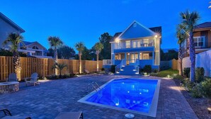 A backyard with a swimming pool, a covered patio, and a two-story house. - 7 BR, Gulf Views, Across From Beach, Movie Theater, Pool/Spa, Discount Golf Cart (Destin)