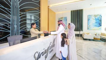 A reception area with a marble counter, a modern interior design, and a painting on the wall.