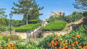 A landscaped garden with stone steps, a lamp post, and a variety of plants.