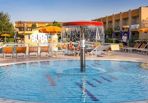 Ein Schwimmbad mit Liegestühlen und einer Wassersäule.