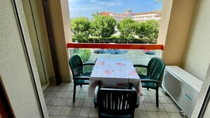 A balcony with a table and chairs, a view of a building, and a radiator. - Poolside Retreat - Beahost (Caorle)