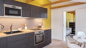 Een moderne keuken met donkere kastjes, een stalen magnetron en een ingebouwde oven.