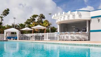 Una piscina al aire libre, camas de piscina gratis, sombrillas