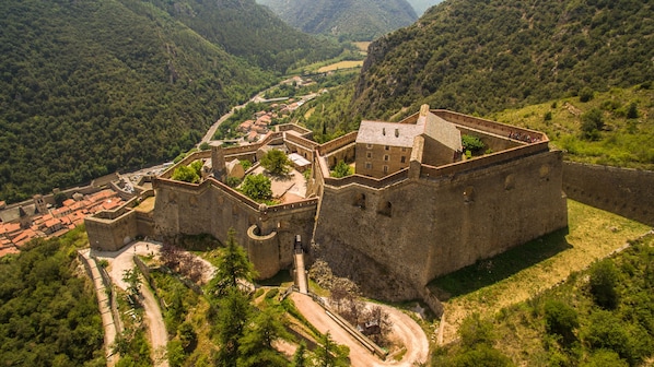 Un château médiéval doté d’une structure fortifiée, d’une cour intérieure et d’un mur d’enceinte.