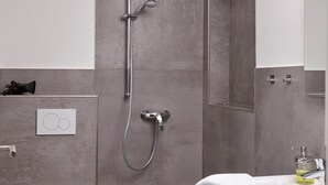 A modern bathroom with a shower, toilet, and sink. - Oystercatcher - Holiday cottage for two (St Peter Ording)