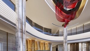 A spacious, modern lobby with a curved ceiling and marble columns. - Jingyang Hotel (Yingshan)