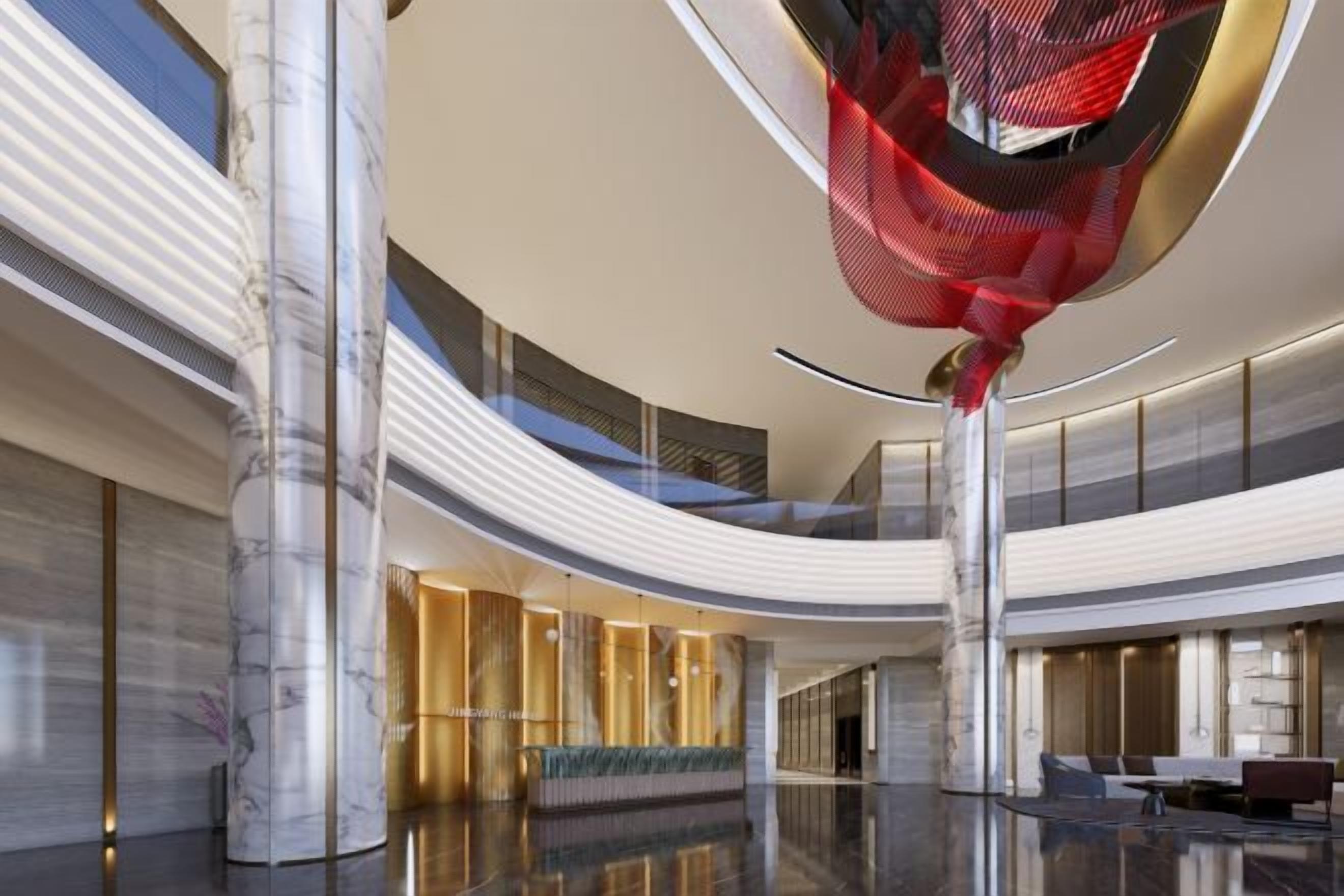Eine großzügige Lobby mit hoher Decke, Marmorsäulen und einer zentralen Sitzecke.