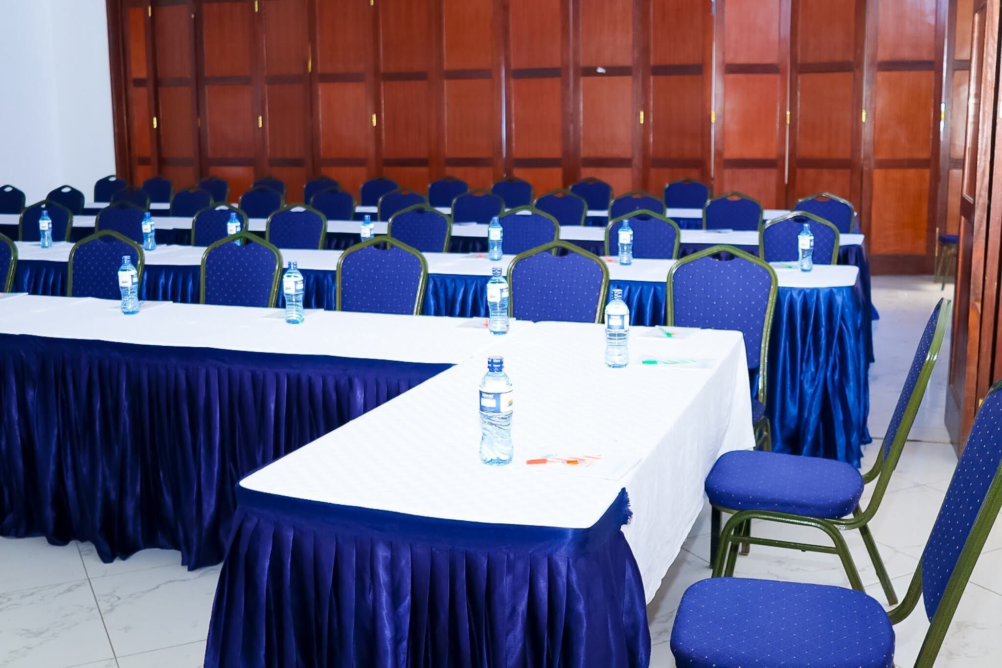 A conference room with tables, chairs, and water bottles.