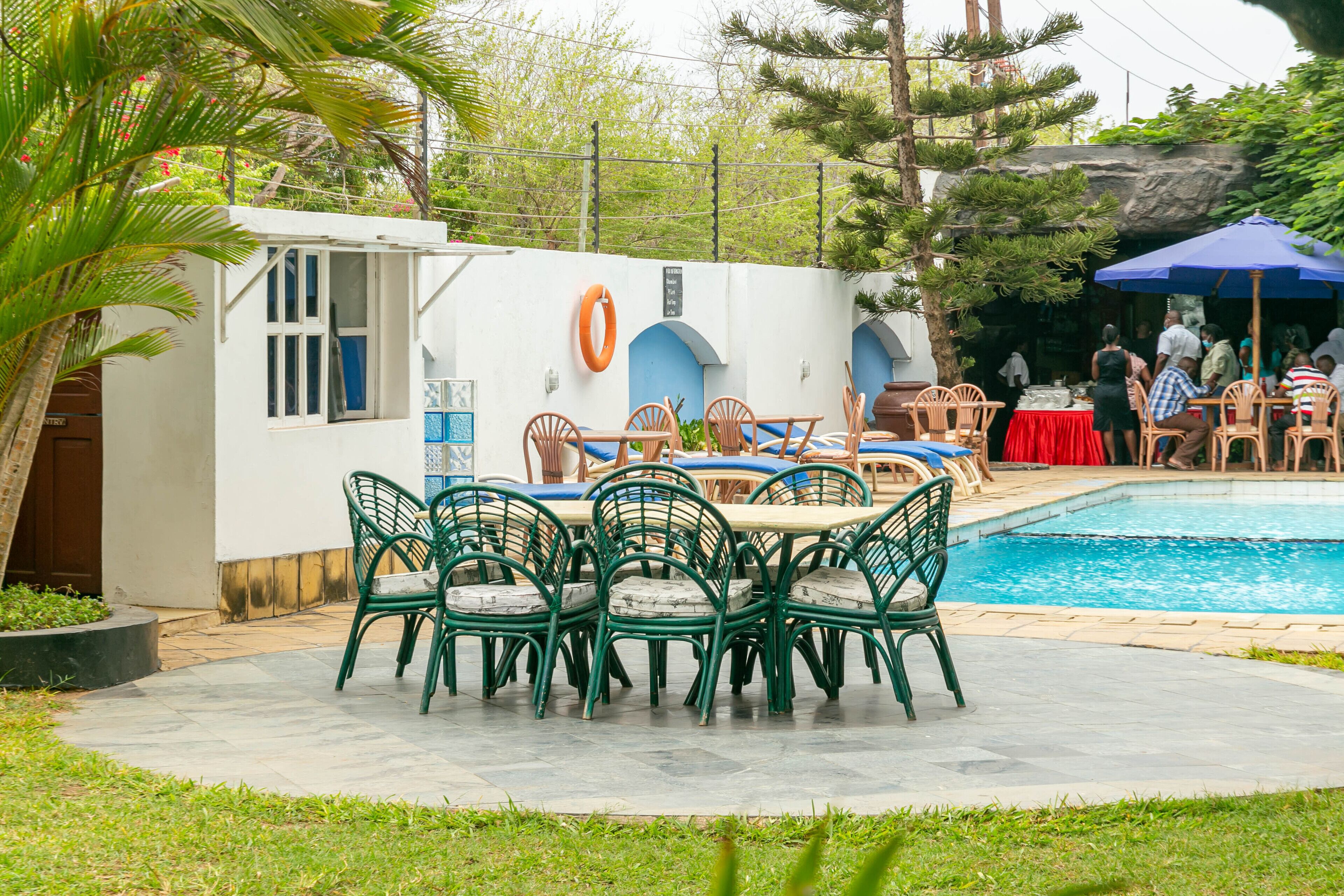 Zona junto a la piscina con mobiliario exterior y un flotador en la pared.