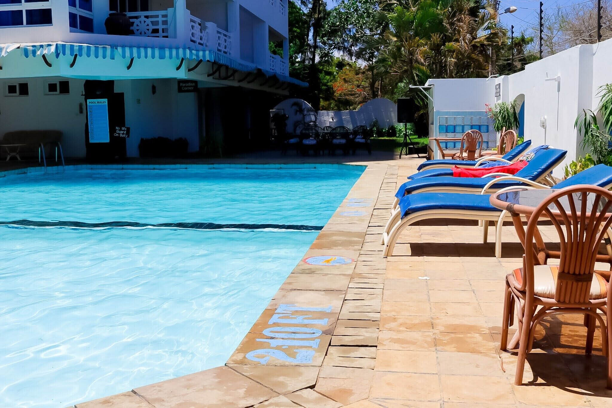 A swimming pool with lounge chairs and a sign indicating a pool area.