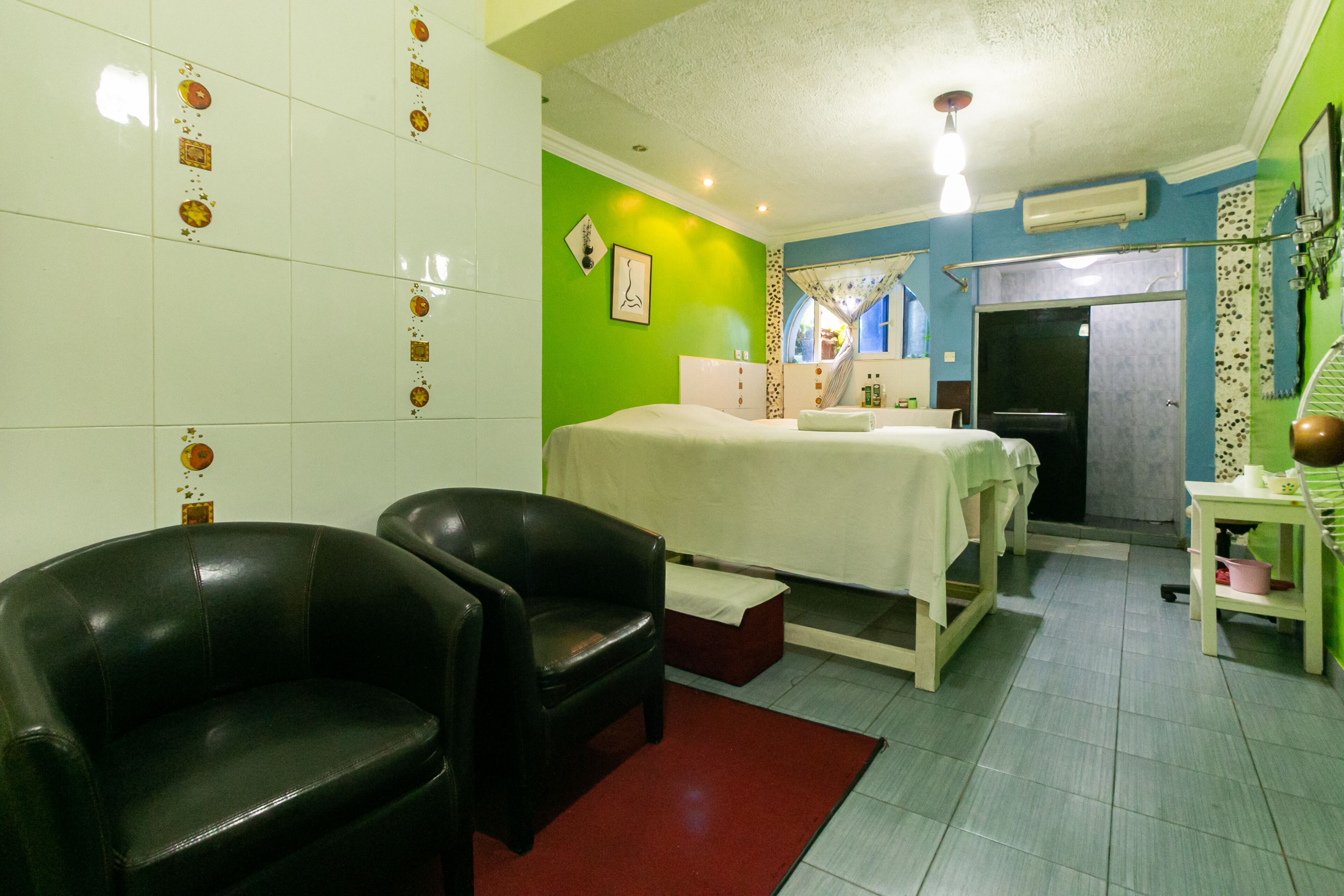 Habitación de hotel con cama, dos sillas, una mesita y ventana con vistas al exterior.