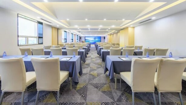 A conference room with multiple tables and chairs, arranged in rows. - RGHCM Garden Resorts (Beijing)