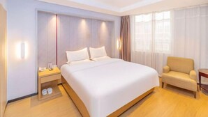 A modern hotel room with a large bed, a bedside table, a chair, and a window with sheer curtains. - RGHCM Garden Resorts (Beijing)