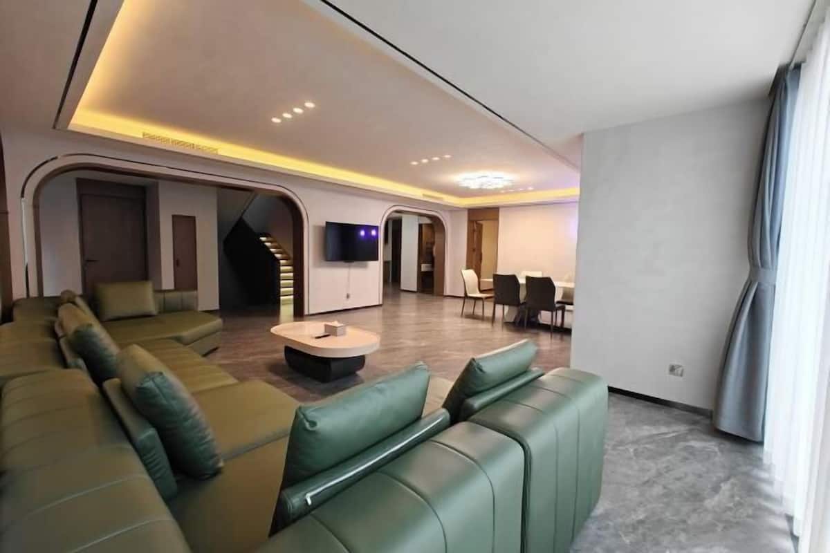 A modern living room with a sofa, a coffee table, and a TV mounted on the wall.