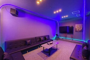 A modern lounge area with a sofa, a coffee table, and a flat-screen TV. - RGHCM Garden Resorts (Beijing)