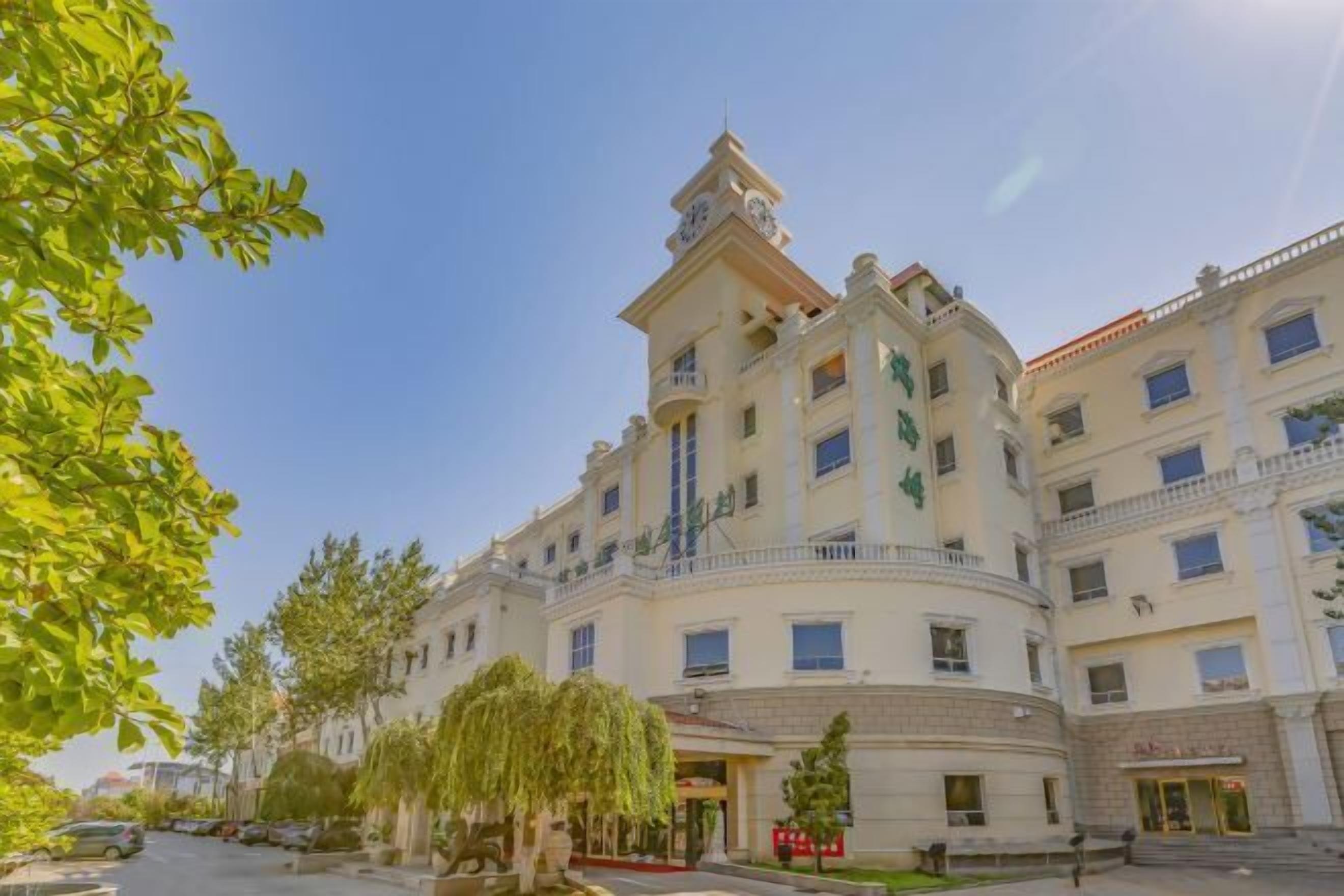 Ein mehrstöckiges Hotel mit einem zentralen Turm, Balkonen und einem Innenhof.