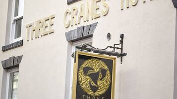 El exterior del Hotel Three Cranes, con su nombre exhibido en letras doradas.
