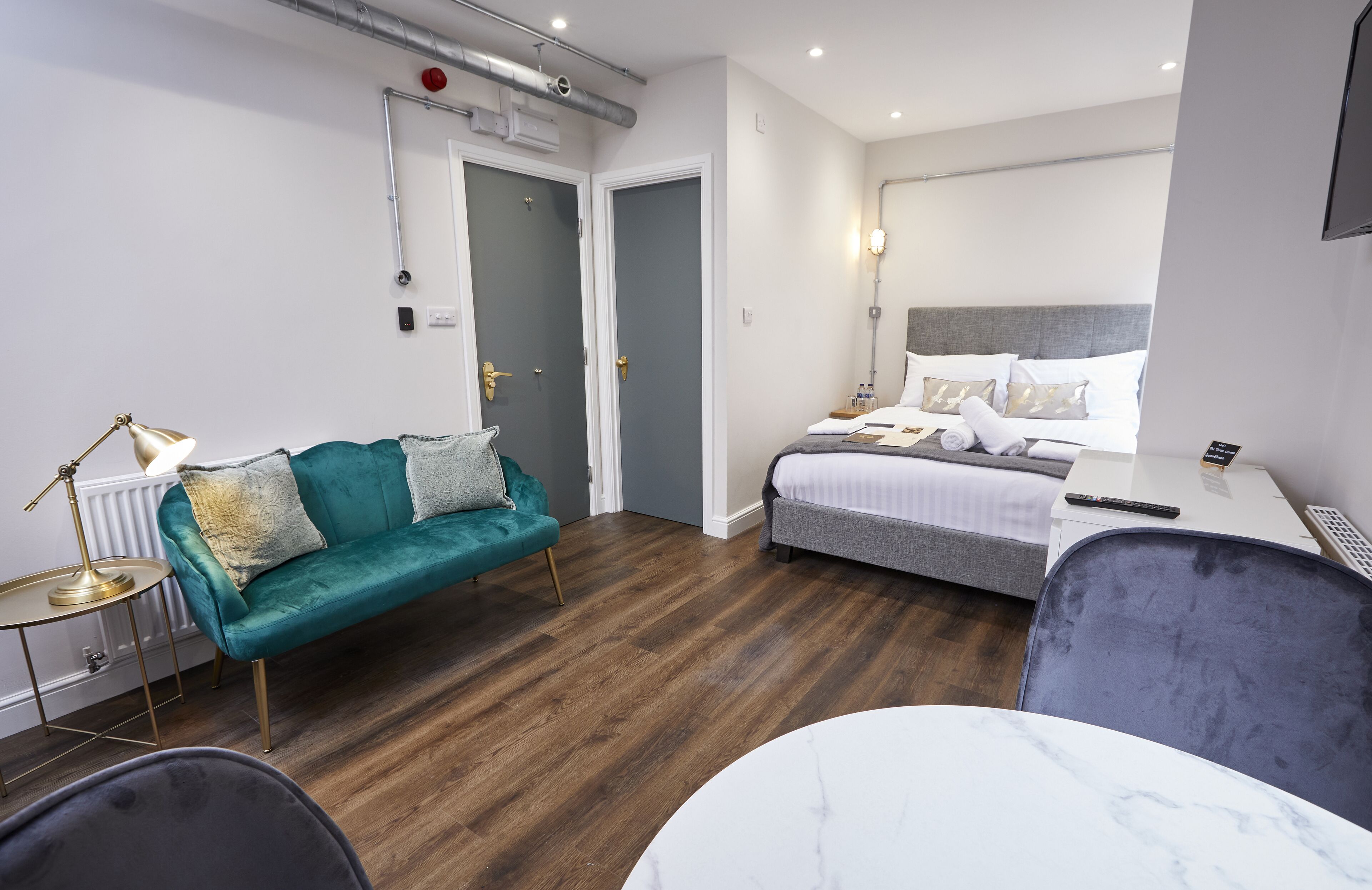 Ein modernes Hotelzimmer mit einem Bett, einem Sofa, einem Schreibtisch und einem Sessel.