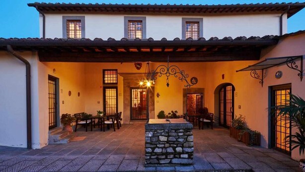 A building with a patio area, stone columns, and a covered seating area. - Limoni Appartment (firenze)