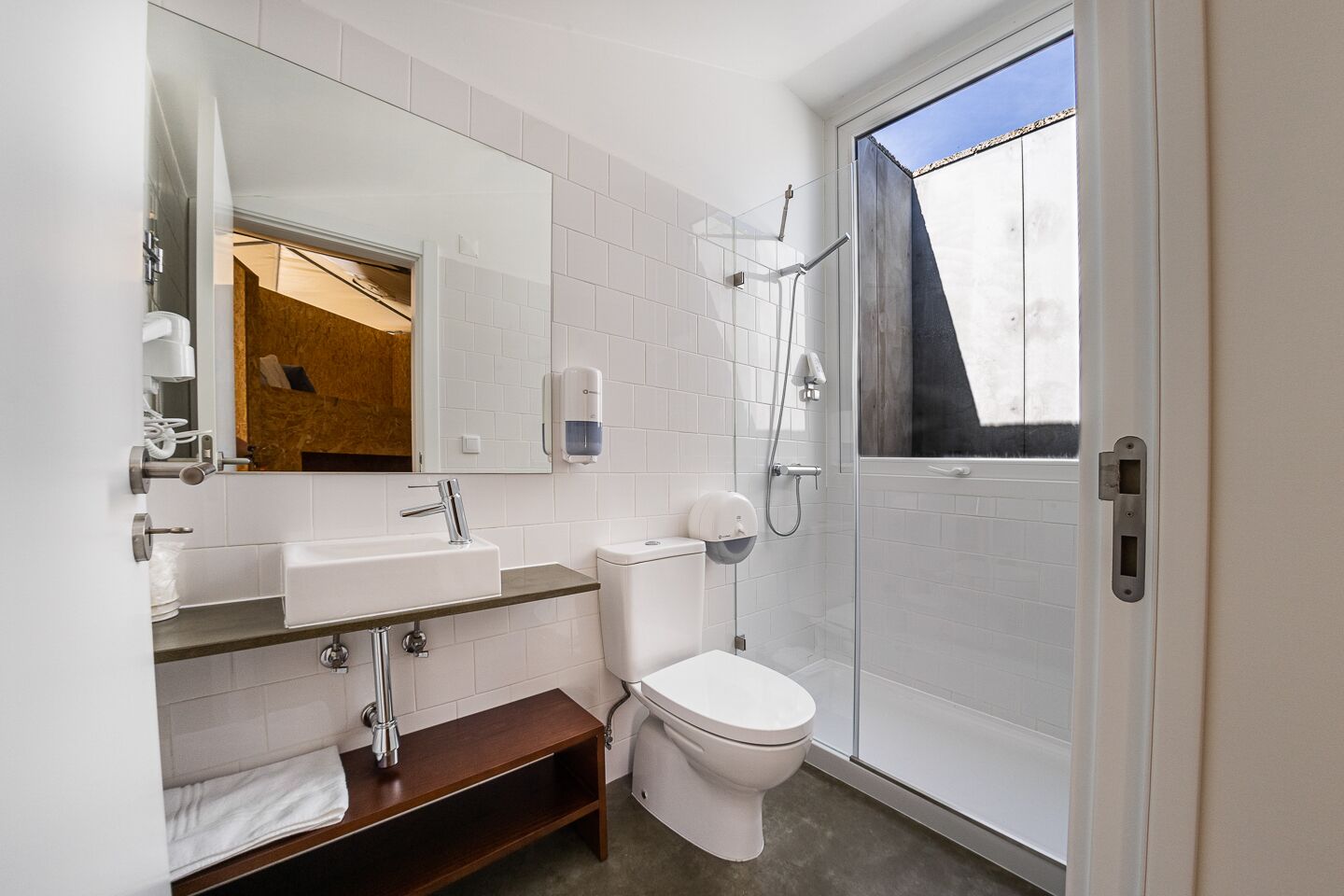 Un bany modern amb un lavabo, vàter i dutxa.