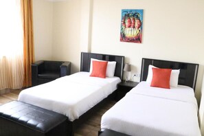 A hotel room with two single beds, a black leather sofa, a painting on the wall, and a window with curtains. - Gigiri Express Hotel (Nairobi)