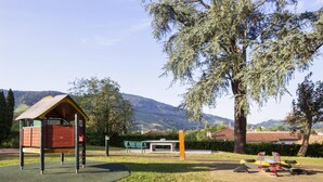A playground with a climbing structure, a bench, and a seesaw. - Apartment Basque Country Saint Jean Pied de Port (Uhart cize)