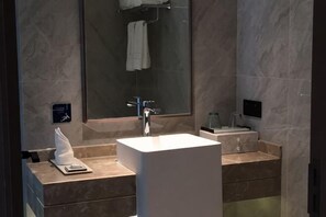 A modern bathroom with a large mirror, a white sink, and a towel rack. - Poli Garden Hotel (Qianwei County)
