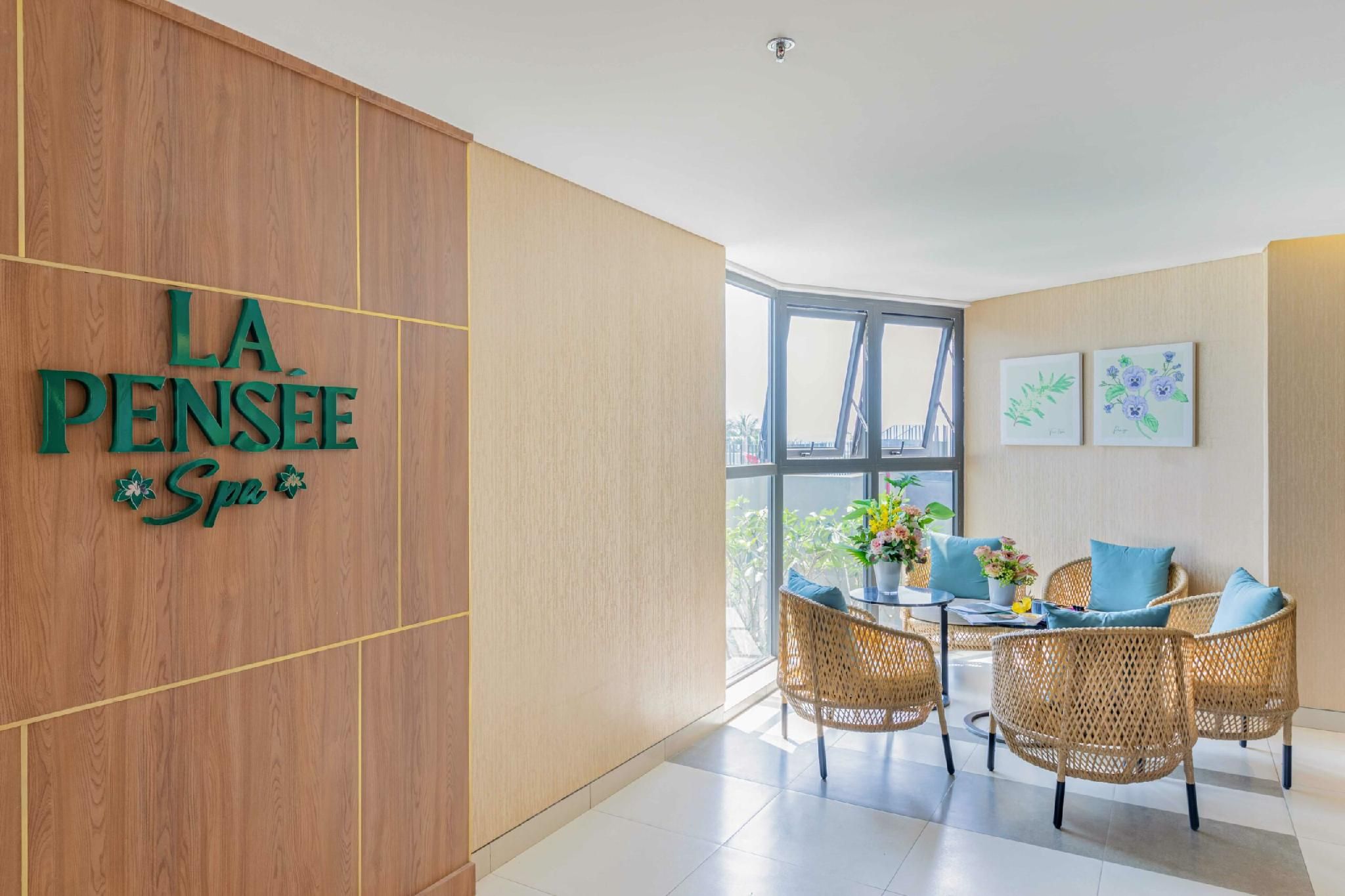 Vestíbulo de hotel con una pared de madera que muestra el nombre 'LA PENSÉE Spa'.