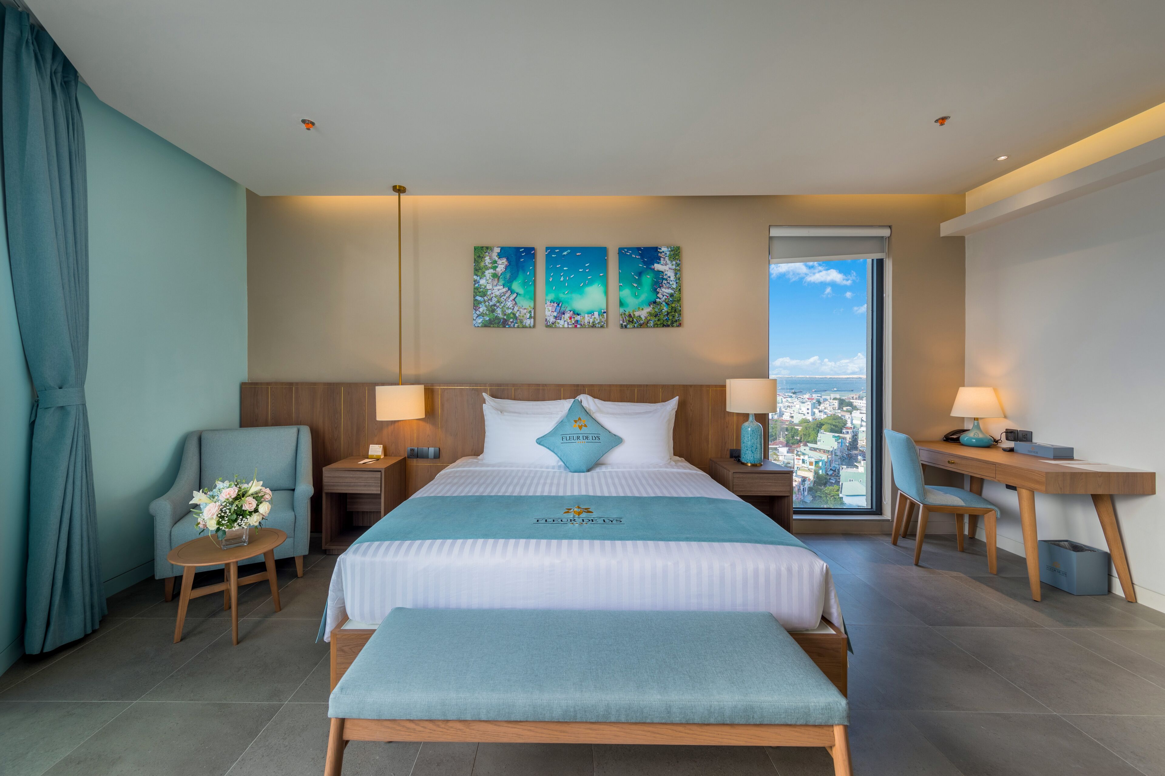 A modern hotel room with a large bed, a desk, and a view of the city.