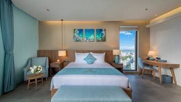 A modern hotel room with a large bed, a desk, and a view of the city.