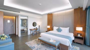 Une chambre d’hôtel moderne dotée d’un grand lit, de tables de chevet, d’un bureau et d’un coin salon.