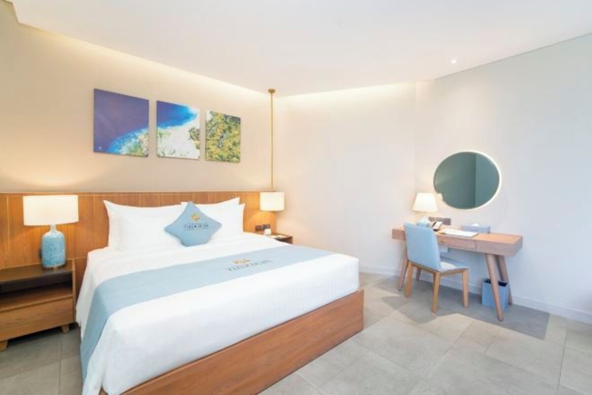 Een hotelkamer met een bed, nachtkastjes, een bureau en een stoel.
