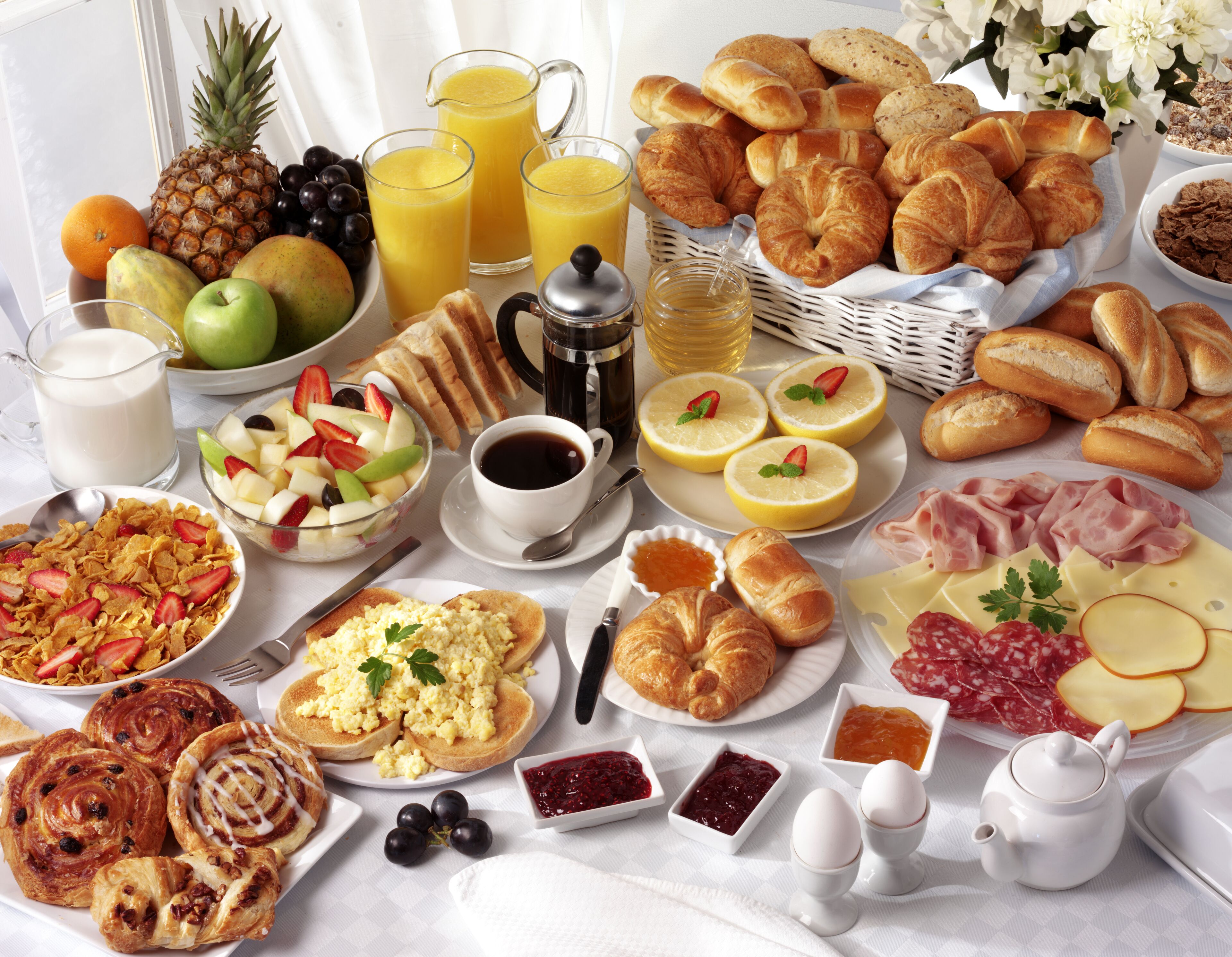 A breakfast buffet with a variety of foods and beverages.