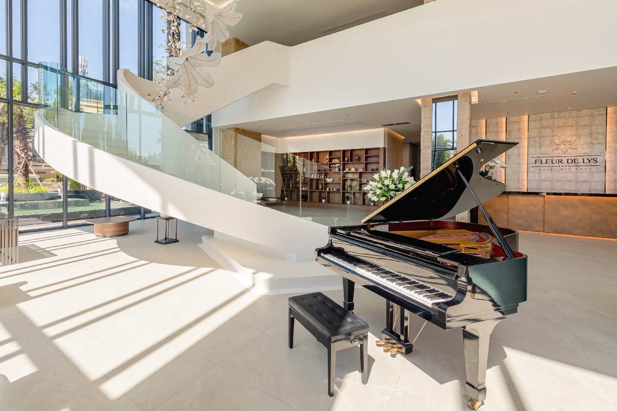 Un piano de cola imponente en un interior moderno y amplio, con una escalera de cristal y vistas al exterior.