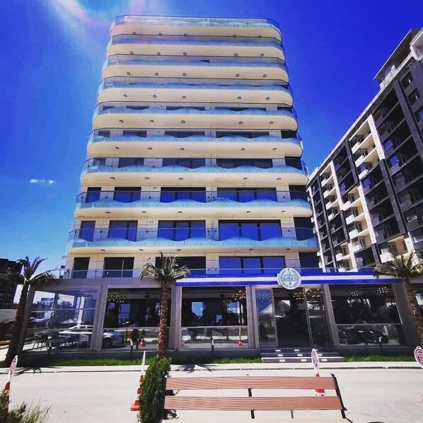A multi-story hotel with a modern design, featuring a prominent entrance with a blue awning and a logo. - Resort Stefan (Navodari)