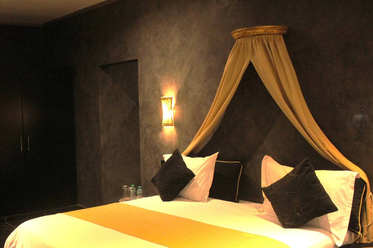 Ein Hotelzimmer mit einem großen Bett, einer Couch und einem Kleiderschrank.