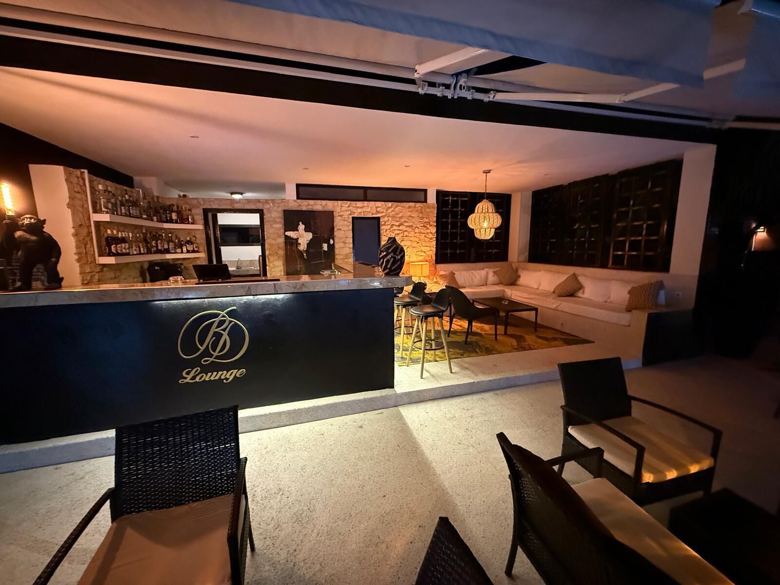 Un espace détente avec un bar, des sièges et un mur en pierre.
