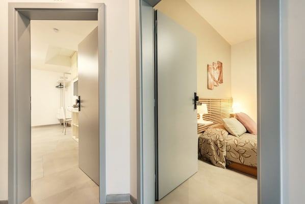 A modern bedroom with a bed, bedside table, and a wall-mounted artwork.