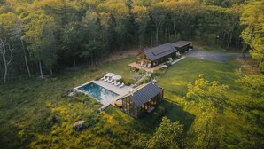 A modern house with a swimming pool, surrounded by dense forest. - A Retreat @ Hudson Woods With Pool & Hot Tub (Kerhonkson)