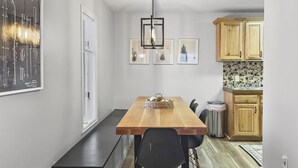 A compact kitchen with a wooden table and chairs, a hanging light fixture, and a tiled backsplash. - Great views from condo w/free winter shuttle (Brian Head)