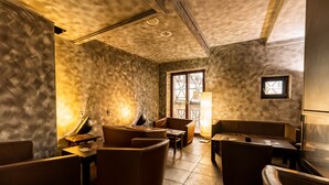 A cozy lounge area with leather seating, a small table, and a window with a view.
