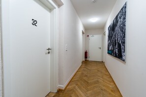 Corridors lead to door 32, featuring a large black and white photograph on the wall.