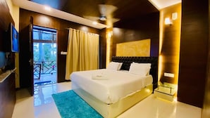 A hotel room with a bed, a ceiling fan, a window with curtains, and a view of the outdoors.
