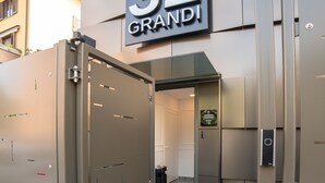 A modern building entrance with a sign reading "32 GRANDI". - GRANDI 32  Boutique Residence (Segrate)