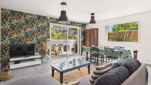 A modern living room with a TV, sofa, and dining area.