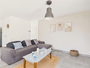 A modern living room with a sofa, coffee table, and wall art.