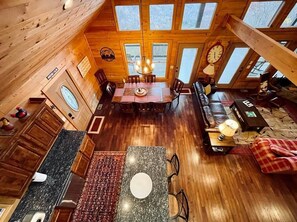 A spacious cabin with a dining area, kitchen, and living room, featuring wooden walls and large windows. - Sunset Ridge Lodge - Breathtaking mountain views and spectacular sunsets ALL seasons + rafting tix (Bryson City)