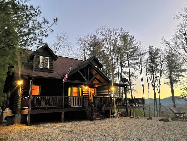 A log cabin with a porch, a staircase, and a view of the surrounding forest. - Tree Top Getaway close to Fontana Lake and NOC - Free Train Tix! (Almond)