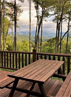 A wooden deck with picnic tables overlooking a forested mountain range. - Tree Top Getaway close to Fontana Lake and NOC - Free Train Tix! (Almond)